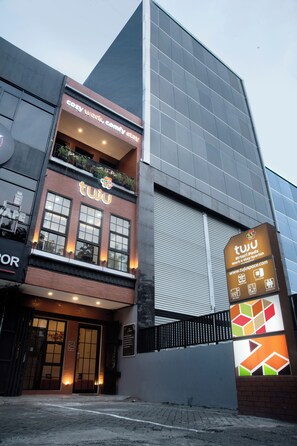 Un edificio moderno con un cartel de 'tuju' que muestra una página web y un logotipo.