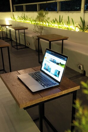 A laptop on a wooden table with a website open on the screen. - Tuju Arteri Pods by Zuzu (Jakarta)