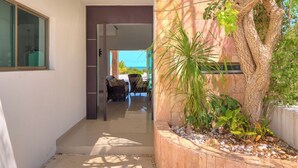 A modern building with a glass door leading to a patio area. - Casa Palmares - Yucatán Home Rentals (Telchac Puerto)