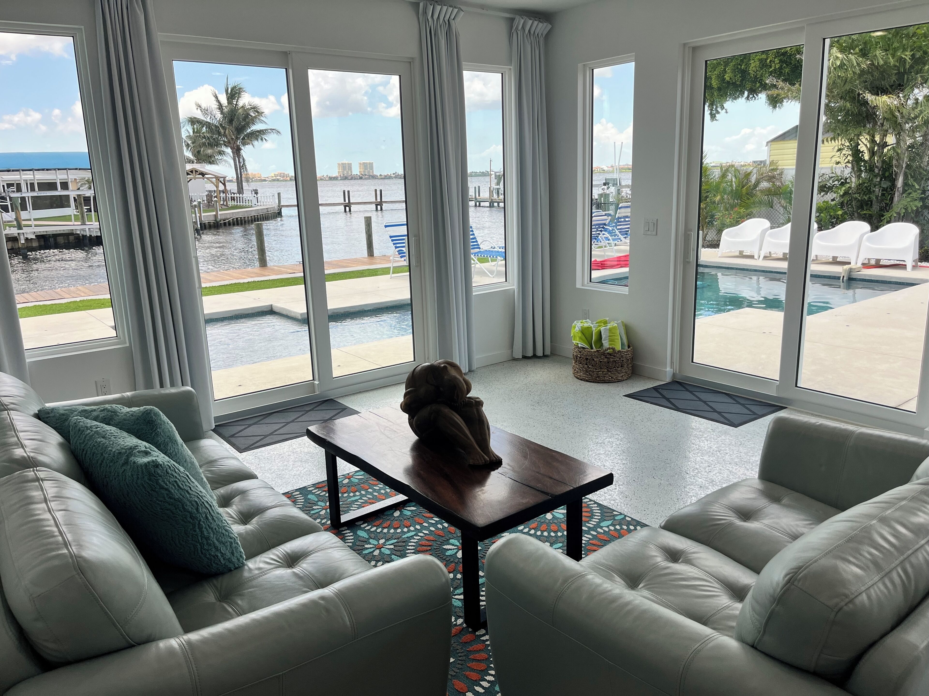 Ein modernes Wohnzimmer mit Blick auf einen Pool und eine Marina.