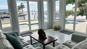 A modern living room with a view of a pool and marina. - Waterfront oasis, sunsets, heated pool, hot tub, boat dock, near boat ramp (Bradenton)