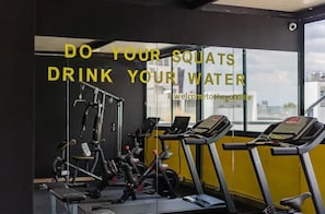 A gym with exercise equipment, a window, and motivational text.