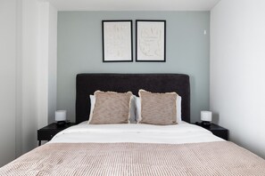 Relax in a serene space with a large bed, bedside tables, and framed artworks.