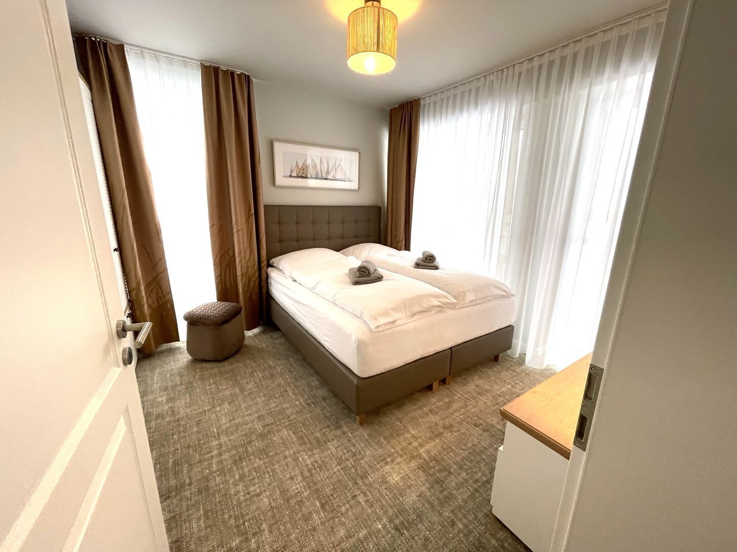 Una camera d'albergo con un letto, un comodino, una lampada e un quadro appeso al muro.