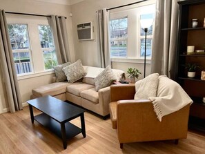 A living room with a sectional sofa, a coffee table, and a bookshelf. - Lodi Lounge: Private Spa + Walkable to Downtown (Lodi)