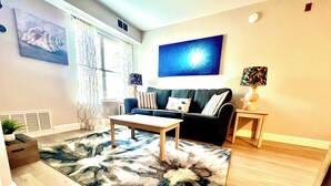 Una sala de estar con sofá, mesa de centro y alfombra.