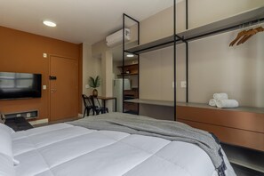 A modern hotel room with a bed, a TV, a desk, and a wardrobe. - Av0811 Studio Avanhandava (São Paulo)