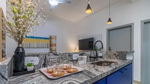 A modern kitchen with a marble countertop, blue cabinets, and a large mirror. - Leo166-4 in S o Paulo (São Paulo)