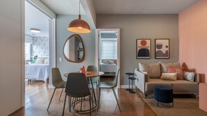 A modern living room with a sofa, chairs, a dining table, and a coffee table. There is a mirror on the wall and artwork above the sofa. - Ac690-112 in S o Paulo (São Paulo)