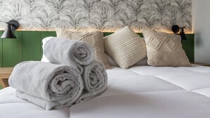 A neatly made bed with rolled towels, a patterned headboard, and two black bedside lamps. - Ac690-112 in S o Paulo (São Paulo)