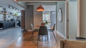 A modern kitchen with a dining area, a hanging pendant light, and a view of the city skyline. - Ac690-112 in S o Paulo (São Paulo)