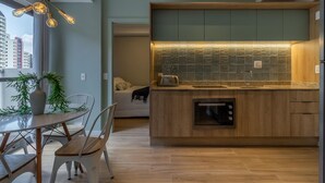 Een moderne keuken met een houten aanrechtblad, een ingebouwde oven en een spatwand met een geometrisch patroon.