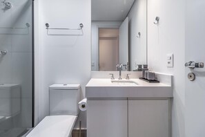 Une salle de bain moderne équipée de toilettes, d’un lavabo et d’une douche.