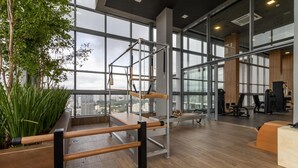 A modern gym with large windows, wooden flooring, and exercise equipment. - HW Rebou As2636-210 (São Paulo)