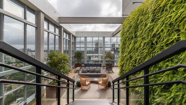 A modern indoor space with a staircase leading to a seating area with a view of the city. - HW Rebou As2636-210 (São Paulo)