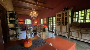 A rustic kitchen with a central island, wooden cabinets, and a chandelier. - Casagon Alves in Gon Alves (Gonçalves)