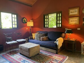 A cozy living room with a sofa, ottoman, and chairs, a patterned rug, and a lamp. - Casagon Alves in Gon Alves (Gonçalves)