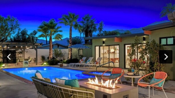 Un área de piscina con sillones de descanso y una chimenea.