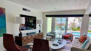 Una sala de estar moderna con un televisor de pantalla plana, una mesa de centro y asientos cómodos.