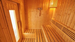 A wooden sauna with a bench, a wall-mounted thermometer, and a window. - Lime Hotel (Patong)