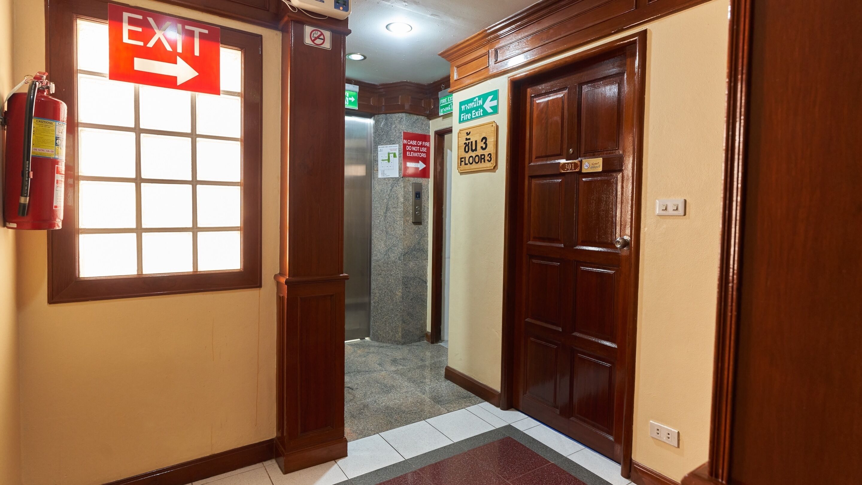 A hallway with an EXIT sign, a fire extinguisher, and a door labeled FLOOR 3.