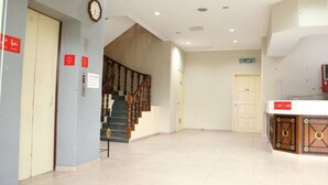 A hotel lobby with a staircase, a reception desk, and a clock on the wall. - Sandakan Inn (Sandakan)