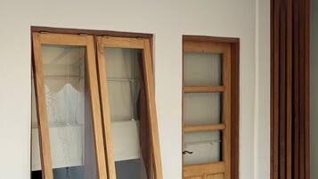 Un edificio blanco con dos ventanas de madera y una puerta de madera.