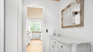 A narrow hallway leading to a kitchen with white cabinetry and a large mirror. - Apartment - Sleeps 4 - Harbour Views - Parking (Aalborg)