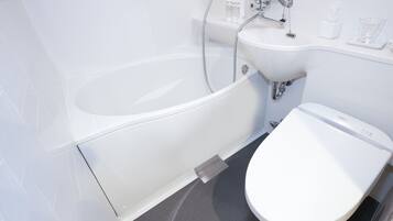 A modern bathroom with a bathtub, sink, and toilet.