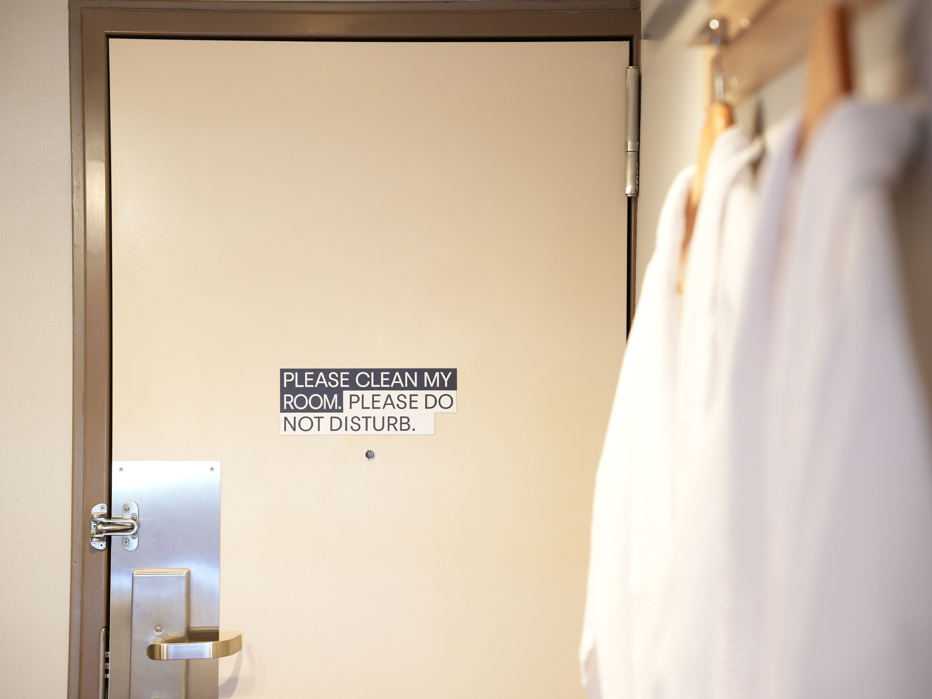 A door with a sign that reads "PLEASE CLEAN MY ROOM. PLEASE DO NOT DISTURB."