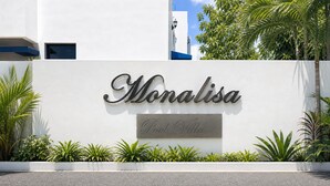 Una pared blanca con los nombres 'Monalisa' y 'Polo Villa' escritos en una fuente decorativa.