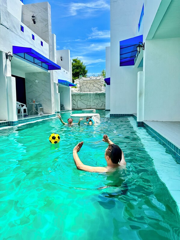 A swimming pool with clear water, a stone waterfall feature, and a sign indicating 'The Oasis Pool Villa'. - Mona Lisa pool villa (Pattaya)