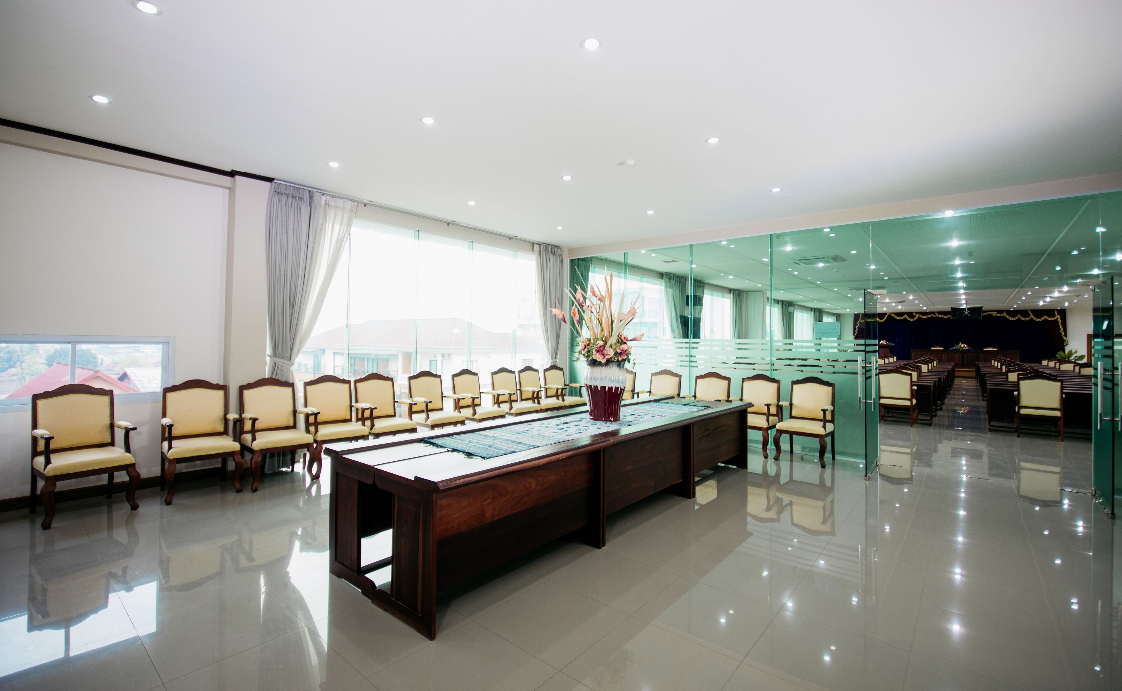 A conference room with a long table, chairs, and a large window.