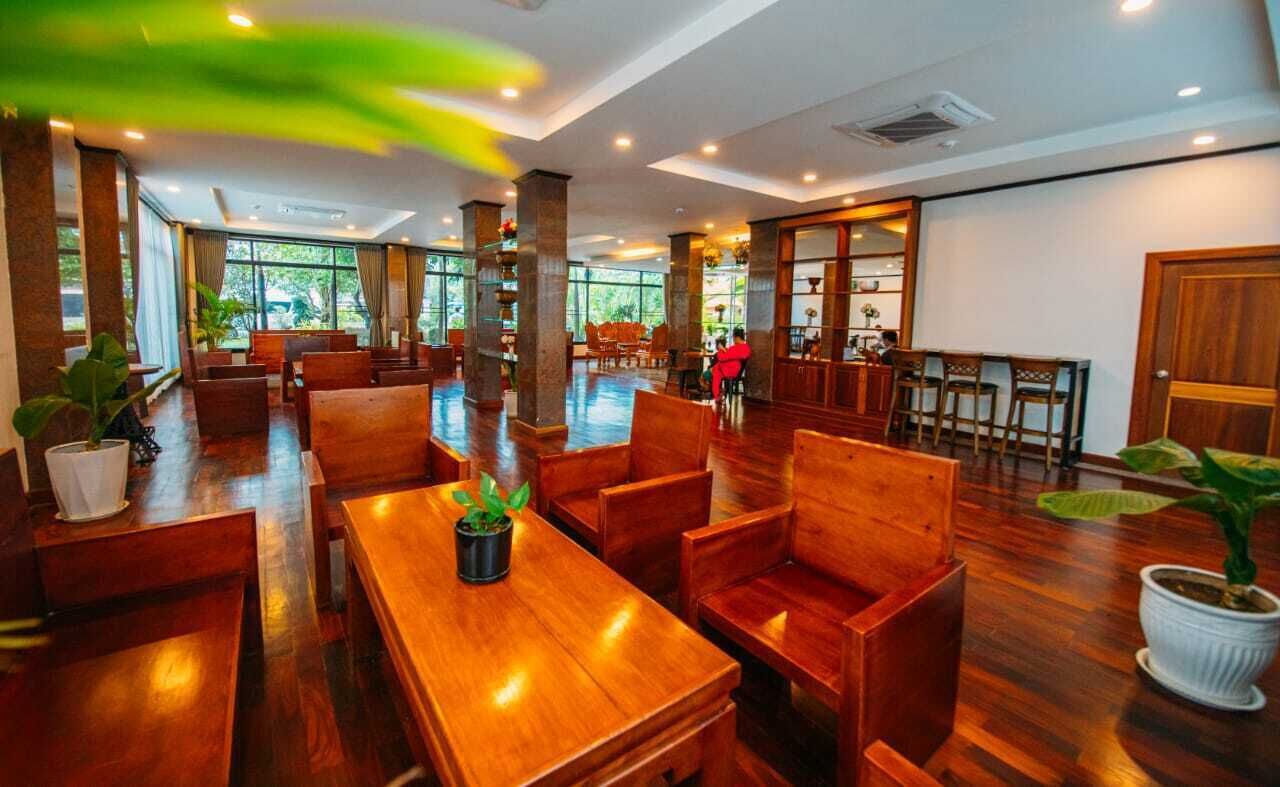 A spacious indoor area with wooden furniture and large windows allowing natural light.