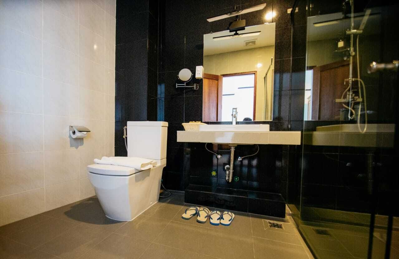 Un baño moderno con inodoro, lavabo y zona de ducha.