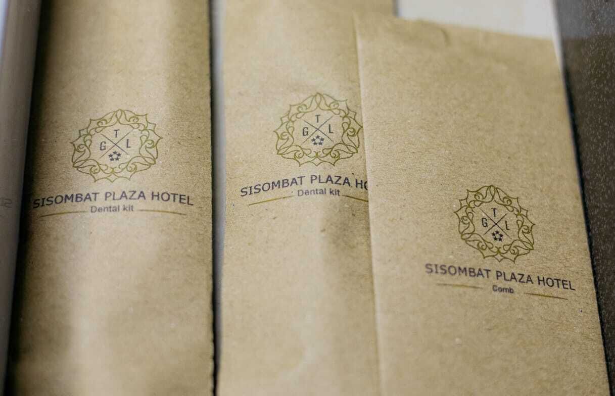 Three brown paper bags with embossed logos and text indicating they are from the Sisombat Plaza Hotel, labeled as 'Dental kit' and 'Comb'.