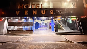 A hotel entrance with a sign reading "HOTEL VENUS" and visible amenities including a bar and a staircase. - Venus Hotel (Colombo)
