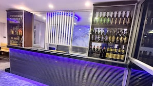 A bar area with a counter, shelves of bottles, and a blue-lit backdrop. - Venus Hotel (Colombo)