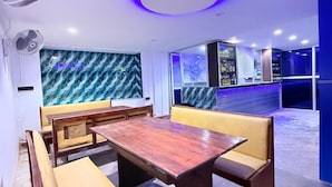 A modern interior with a wooden table and yellow cushioned seating. - Venus Hotel (Colombo)