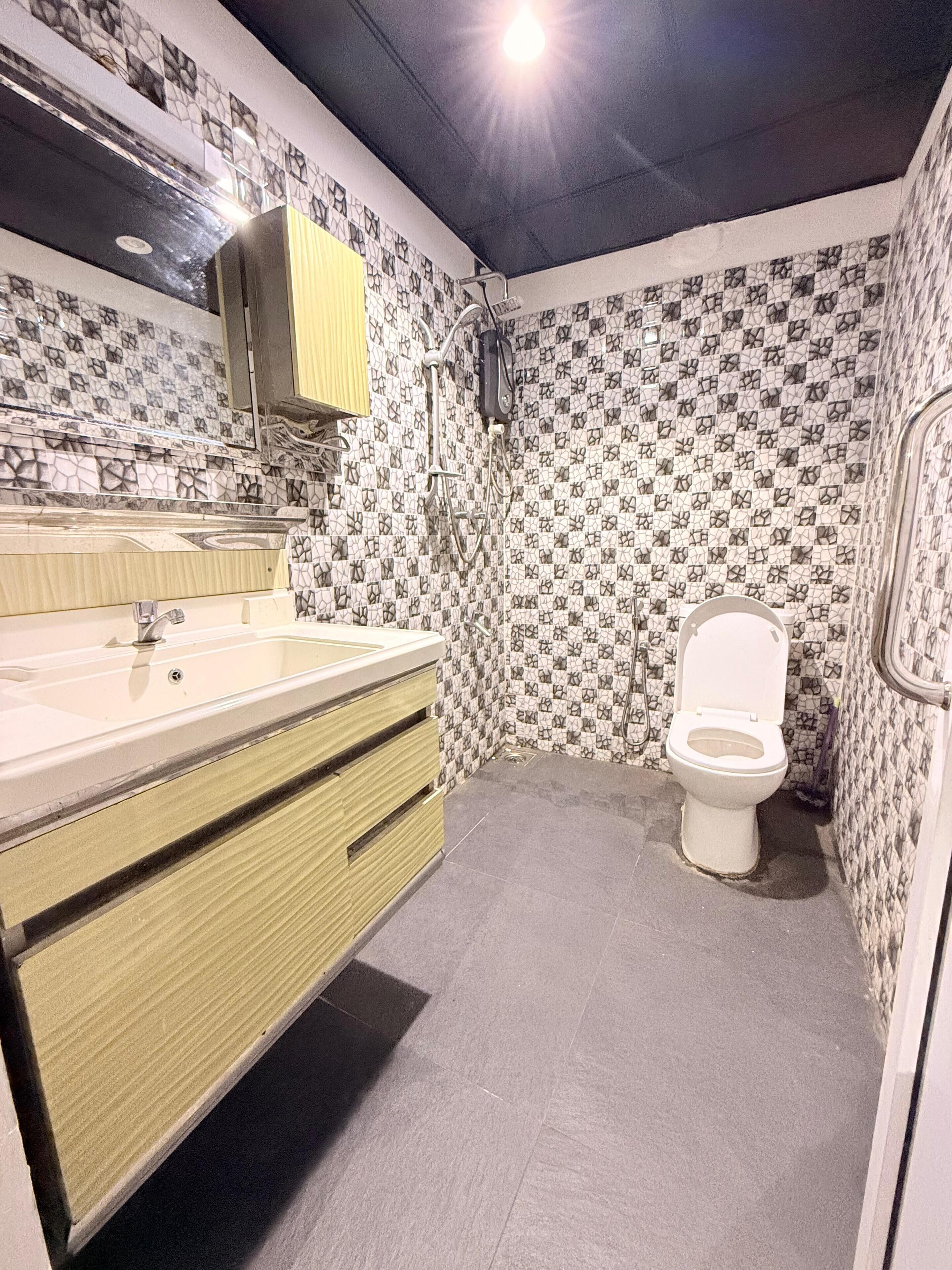 Un baño con lavabo, espejo, inodoro y paredes con diseño.