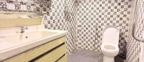 Un baño con lavabo, espejo, inodoro y paredes con diseño.
