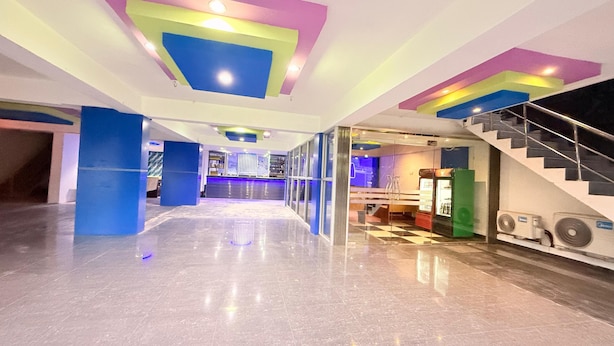 A spacious lobby with a modern design, featuring a central bar area and a staircase leading to upper floors. - Venus Hotel (Colombo)