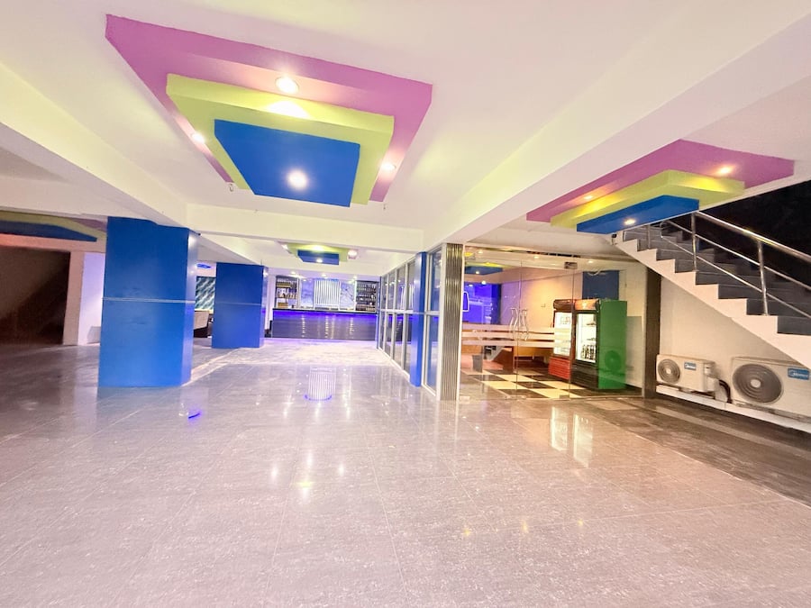 Een ruime lobby met een modern design, met een centraal gelegen bar en een trap naar de verdiepingen erboven.