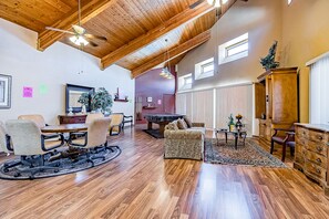 Relax in a warm and inviting space with a comfortable seating area, dining table, and fireplace.