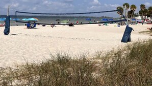 A beach volleyball court with a net, surrounded by sand and palm trees. - View with a View Waterfront WiFi,Furnished,Beaches,New Modern (Tampa)