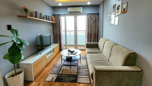 Una sala de estar moderna con un sofá, televisor y una mesa de centro.