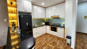 Una cocina moderna con armarios blancos, un refrigerador negro, un lavamanos y una estufa.