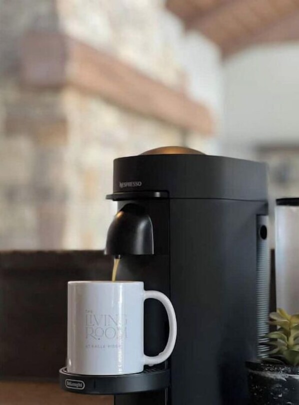 A Nespresso coffee machine with a white mug placed below it. - Private Luxury Spa Retreat -Mountain View, Hot Tub & Sauna (Divide)