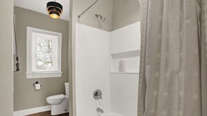 Un baño con inodoro, ducha y bañera.