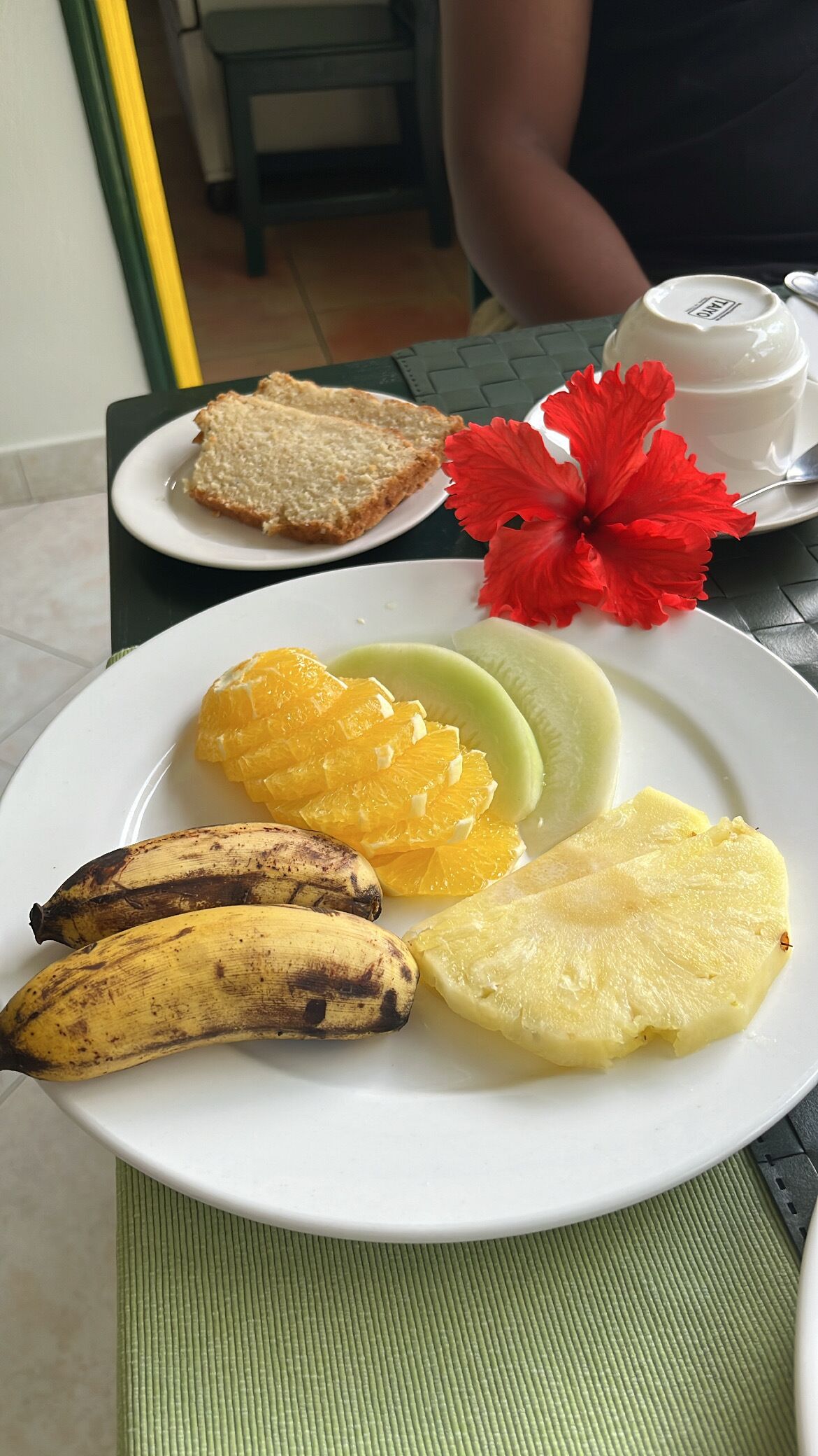 Un plato con tostadas, rodajas de naranja, piña y plátanos.